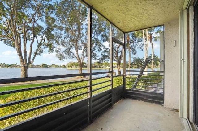 unfurnished sunroom featuring a water view