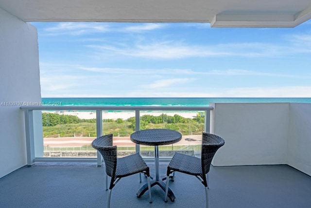 balcony featuring a water view and a view of the beach