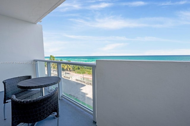 balcony featuring a water view and a beach view