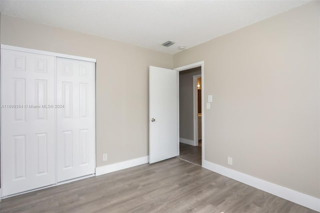 unfurnished bedroom featuring light hardwood / wood-style floors and a closet