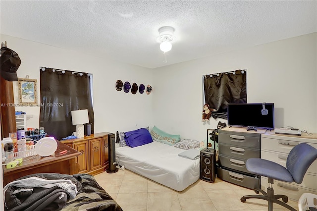 bedroom with light tile patterned floors and a textured ceiling