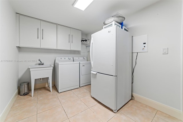 laundry room featuring cabinets, light tile patterned floors, and washer and dryer