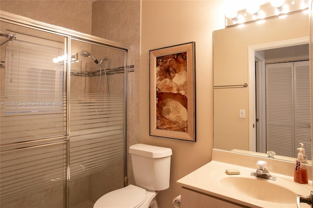 bathroom with walk in shower, vanity, and toilet