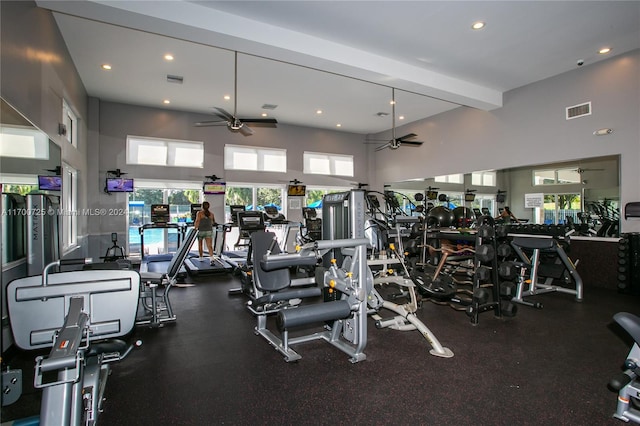 exercise room with a high ceiling and ceiling fan