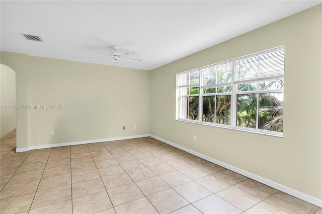 tiled spare room with ceiling fan