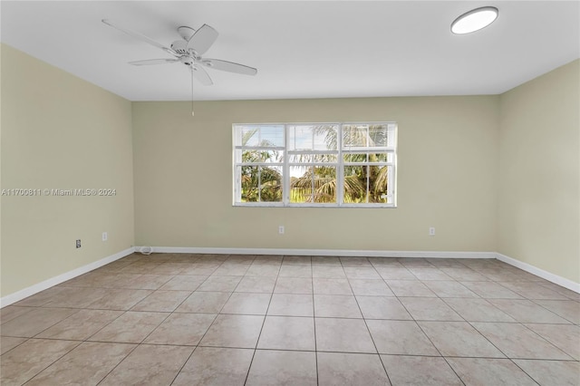 tiled spare room featuring ceiling fan