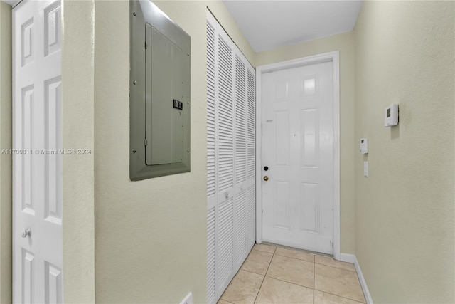 doorway with light tile patterned floors and electric panel