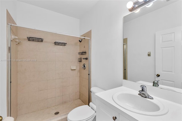 bathroom featuring tiled shower, vanity, and toilet