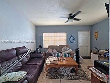 tiled living room with a textured ceiling and ceiling fan