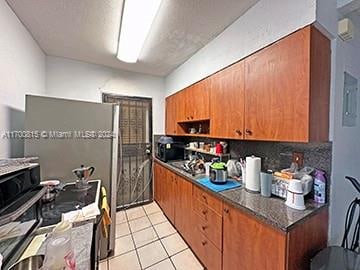 kitchen featuring tasteful backsplash, stainless steel range oven, and light tile patterned flooring