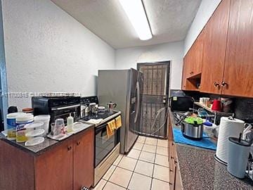 kitchen with light tile patterned floors and stainless steel range with electric cooktop