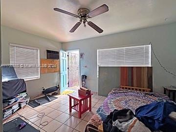 tiled bedroom with multiple windows and ceiling fan