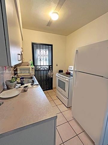 kitchen with light tile patterned flooring and white appliances