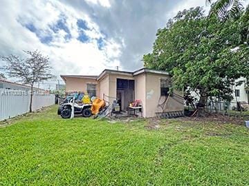 rear view of property with a lawn