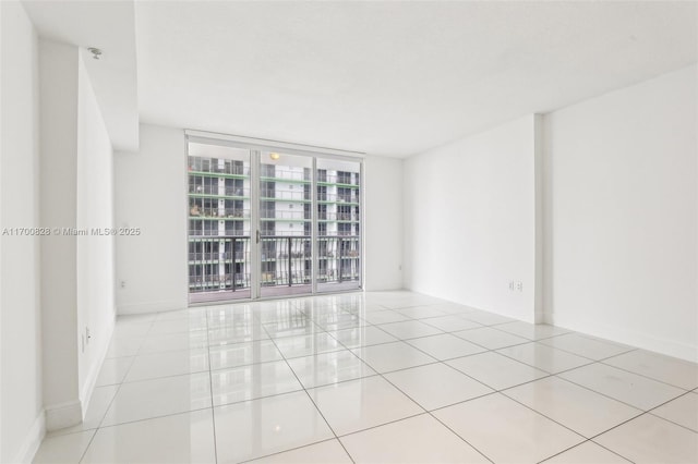 unfurnished room with expansive windows and light tile patterned floors