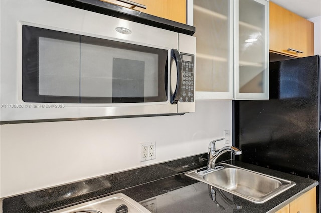 kitchen featuring sink and black refrigerator