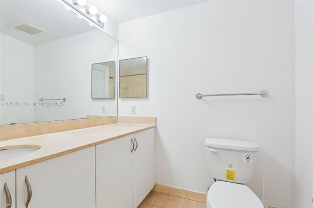 bathroom with vanity, toilet, and tile patterned flooring