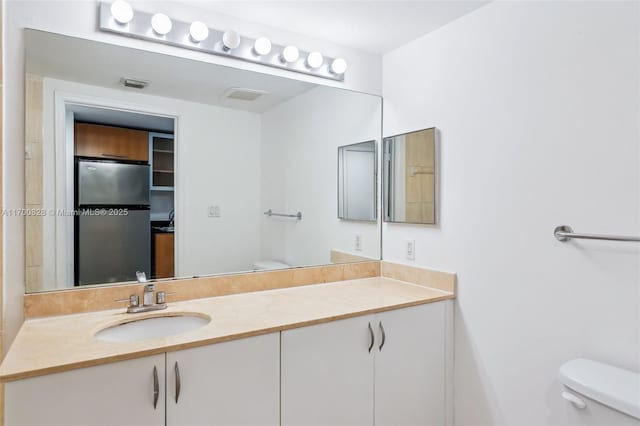 bathroom featuring toilet and vanity