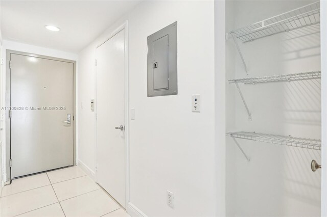 hall with light tile patterned floors and electric panel