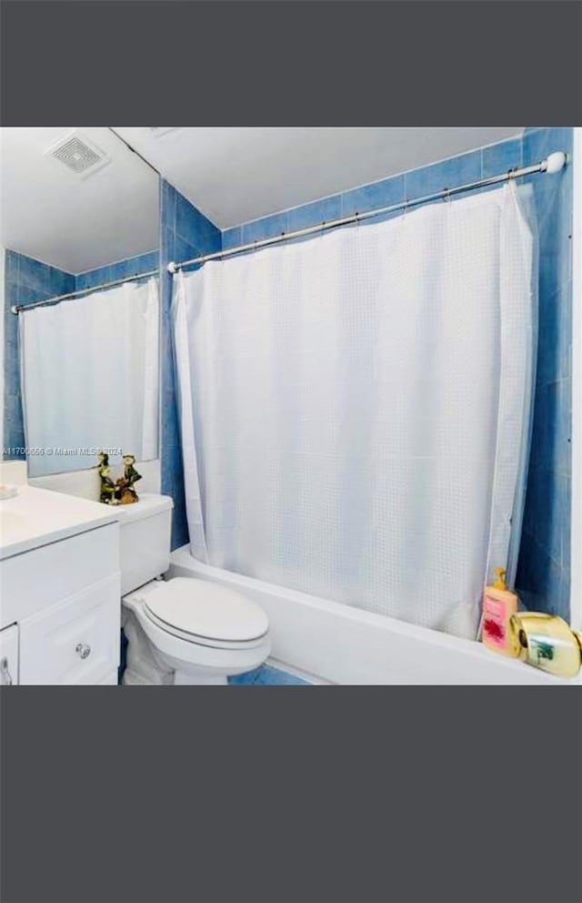 full bathroom with shower / bath combination with curtain, vanity, toilet, and tile patterned floors