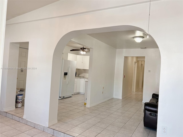 tiled spare room with vaulted ceiling and ceiling fan