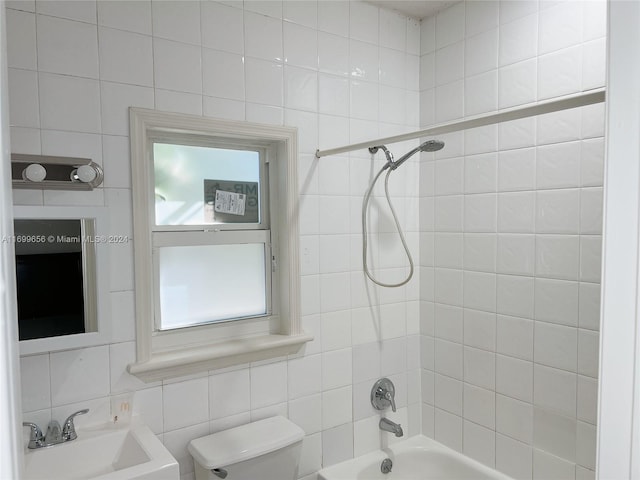 full bathroom featuring tile walls, sink, tiled shower / bath combo, and toilet