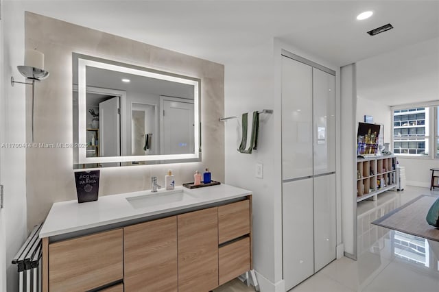 bathroom featuring tile patterned flooring, vanity, and radiator