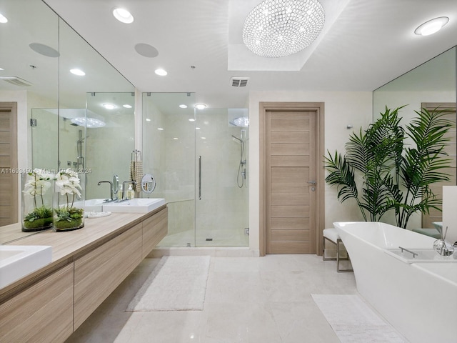 bathroom featuring tile patterned flooring, vanity, an inviting chandelier, and separate shower and tub