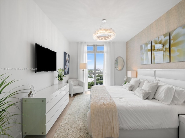 bedroom featuring a chandelier and light wood-type flooring