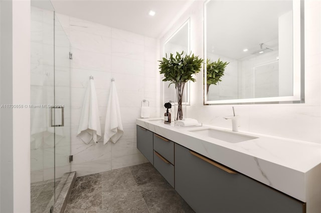 bathroom with walk in shower, vanity, and tile walls