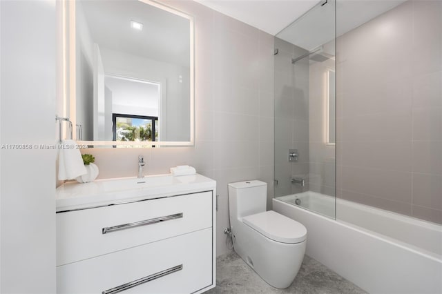 full bathroom with tiled shower / bath combo, toilet, tile walls, and vanity