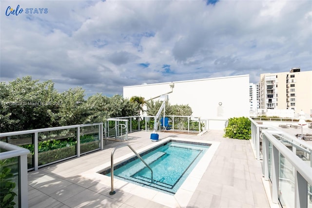 view of pool featuring a patio and a hot tub