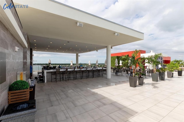 view of patio / terrace featuring a water view and a bar