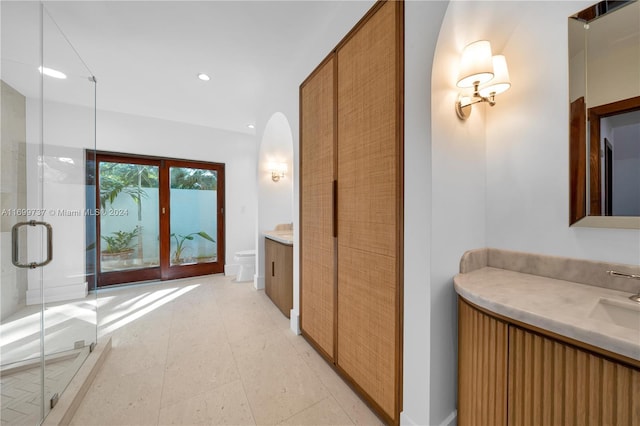 bathroom with a shower with door, vanity, french doors, and toilet