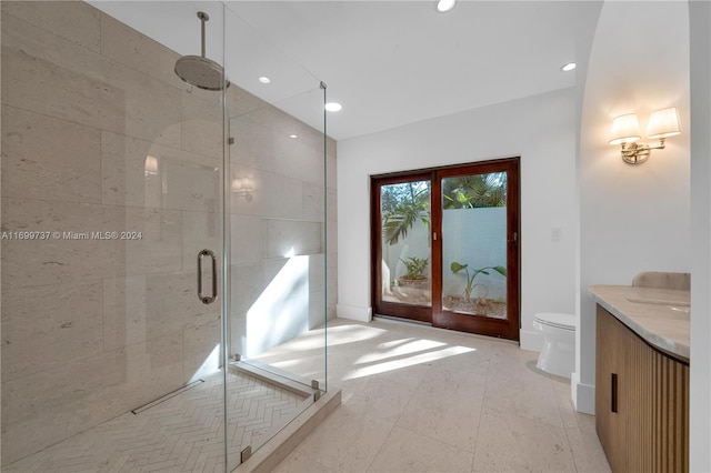 bathroom with tile patterned flooring, vanity, a shower with shower door, and toilet