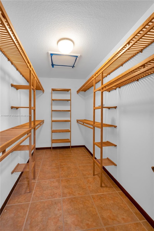 walk in closet with tile patterned floors