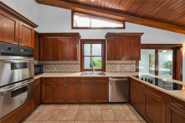 kitchen featuring black appliances, lofted ceiling with beams, and decorative backsplash