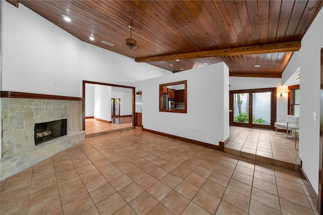 unfurnished living room featuring beamed ceiling, light tile patterned flooring, wooden ceiling, and a fireplace