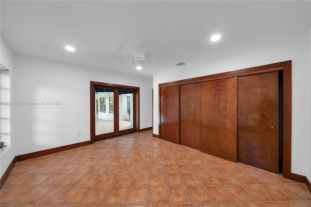 unfurnished bedroom with access to exterior, french doors, ceiling fan, light tile patterned floors, and a closet