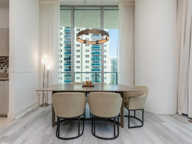 dining space with a notable chandelier and light wood-type flooring