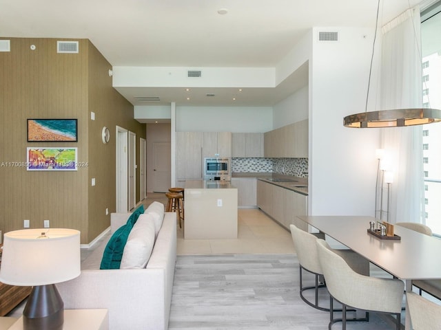 kitchen featuring backsplash, a wealth of natural light, ventilation hood, and light wood-type flooring