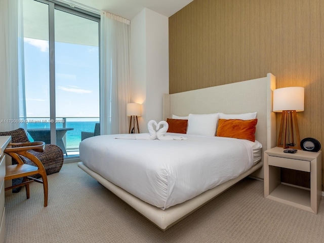 carpeted bedroom featuring access to exterior and a water view