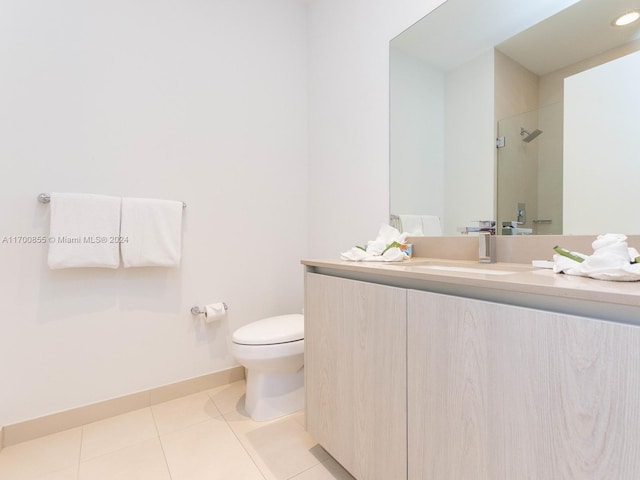 bathroom with tile patterned flooring, vanity, toilet, and a shower with door