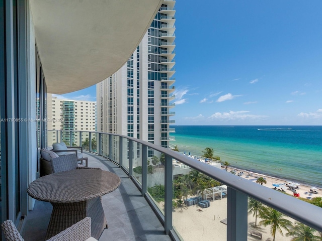 balcony featuring a water view and a beach view