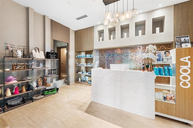 kitchen featuring pendant lighting, a high ceiling, and light tile patterned flooring