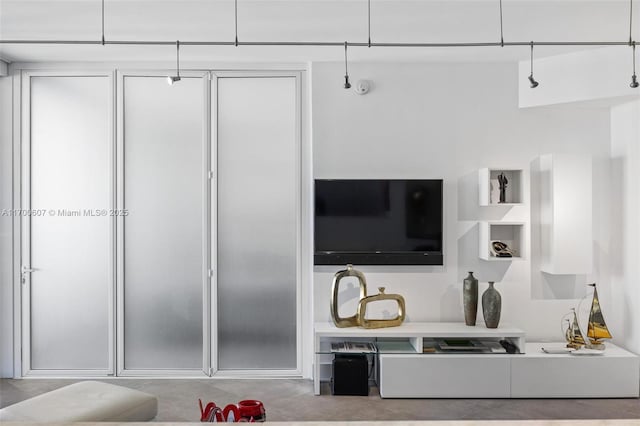 living room with concrete floors and track lighting