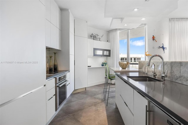 kitchen featuring backsplash, black cooktop, extractor fan, white cabinets, and oven