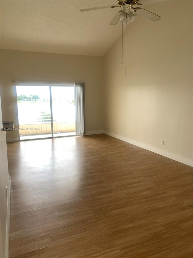 unfurnished room with dark hardwood / wood-style floors, ceiling fan, a textured ceiling, and vaulted ceiling