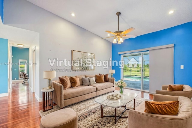 living room with ceiling fan, light wood-type flooring, and lofted ceiling