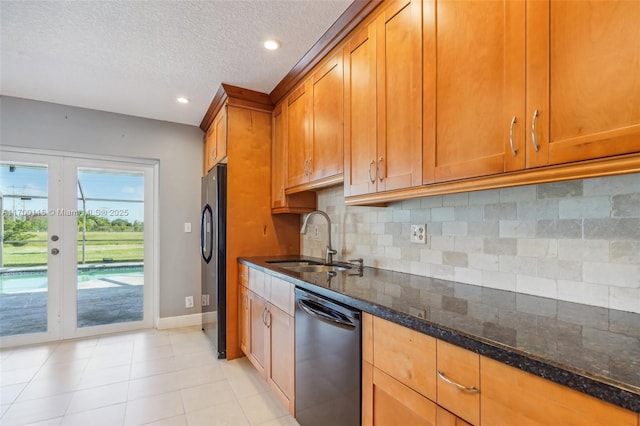 kitchen with french doors, black fridge, dark stone counters, sink, and dishwasher